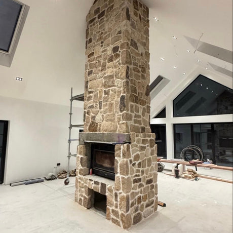 Stone fireplace in a modern room with white walls and ceiling.