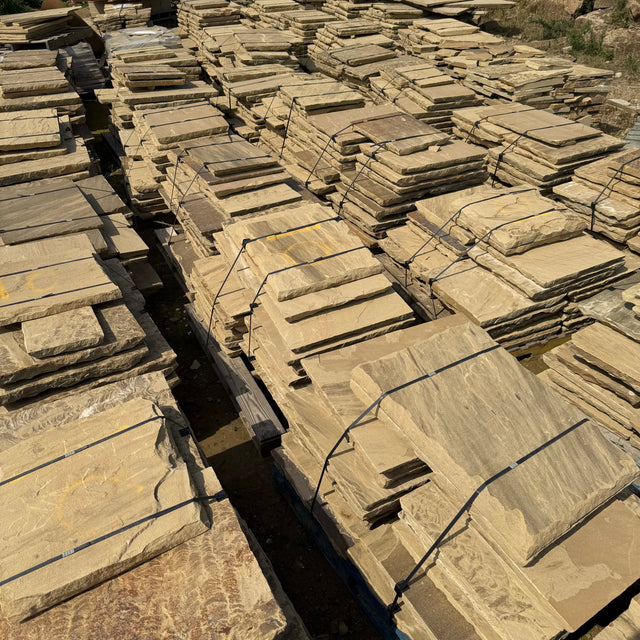 Stacks of stone slabs arranged in rows outdoors