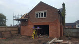Brick slip external cladding installation in progress on rear wall of house