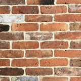 Close-up of a brick wall with varying brick sizes and colors.