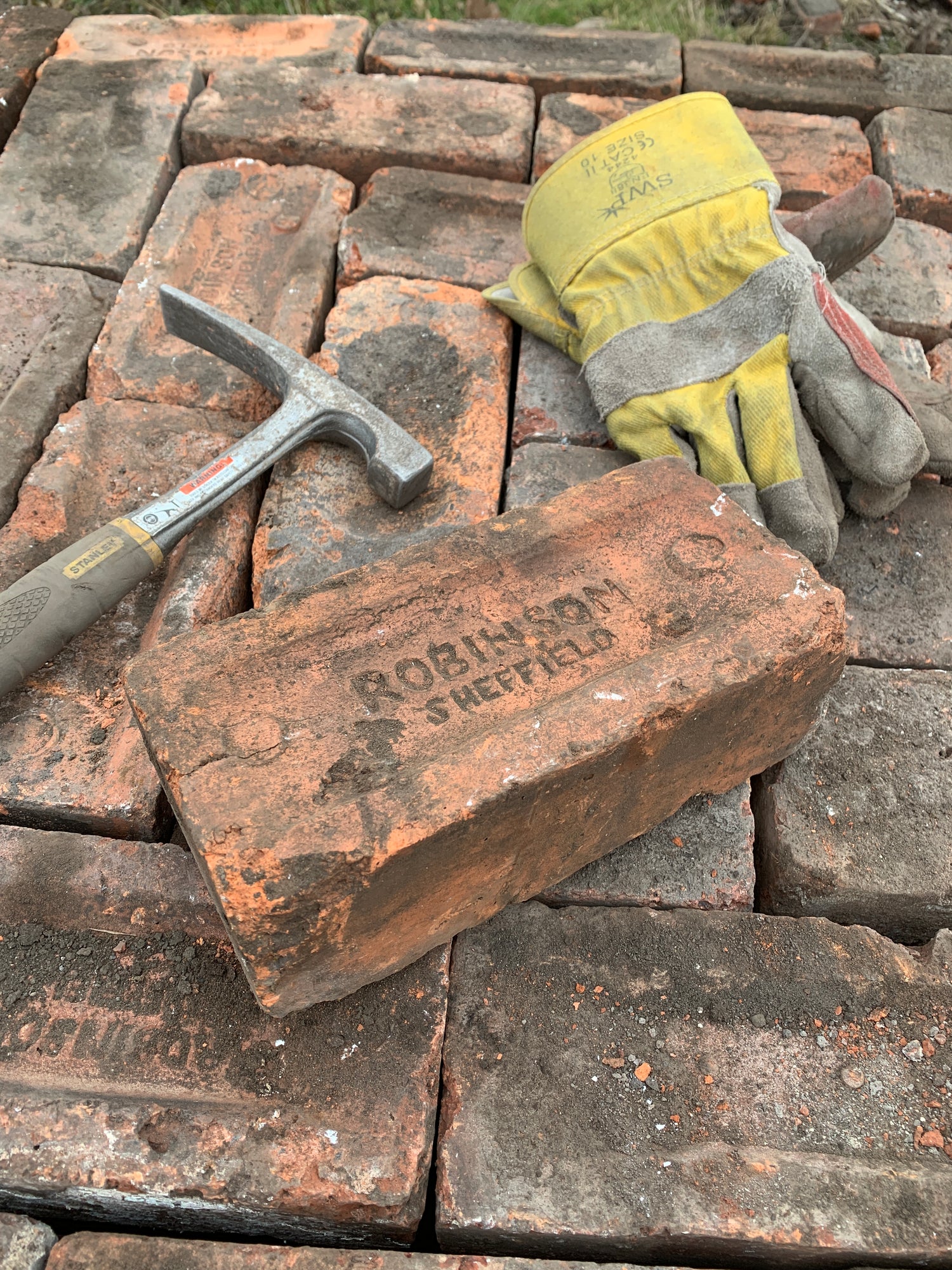 Reclaimed Sheffield bricks with brick-cleaning tools ready for restoration and reuse